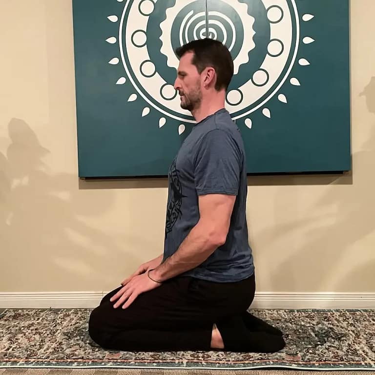 Yoga studio instructor showing spine alignment tips